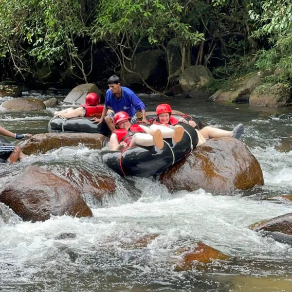 Couple stuck on rocks while tubing during the Phuket Khao Lak Kapong Tubing Waterfall Jungle Trekking Tour