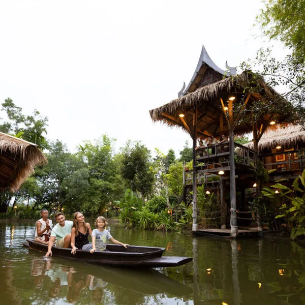 A family floating in a small wooden Thai boat at the Siam Niramit Thai cultural show and dinner in Phuket