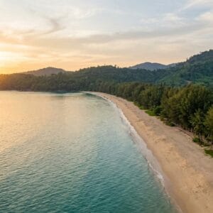 Empty golden-hour beach in Khao Lak Thailand with turquoise sea and jungle hills — things to do in Khao Lak Thailand