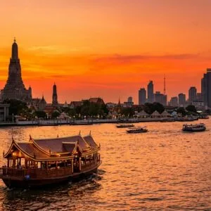 Bangkok first-time visitor guide – dinner cruise on the Chao Phraya River at sunset with the Temple of Dawn in the background