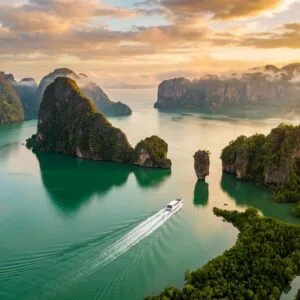 Phang Nga Bay day trip hidden gems — limestone karsts and private speedboat on emerald water at golden hour